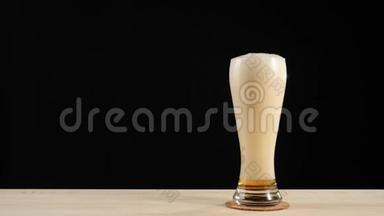 新鲜<strong>啤酒</strong>。 <strong>啤酒</strong>杯杯中的美味工艺<strong>啤酒</strong>放在黑色背景下的木桌上。 带水的冷鲜<strong>啤酒</strong>